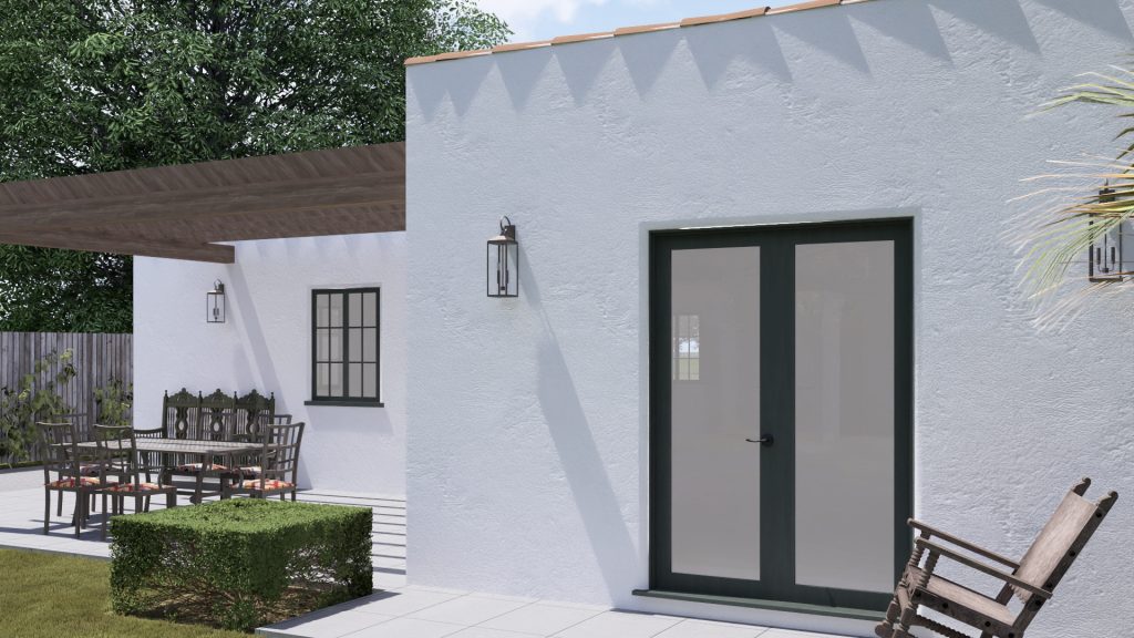 Modern white residential addition with black framed glass doors, patio area with furniture, and manicured hedges
